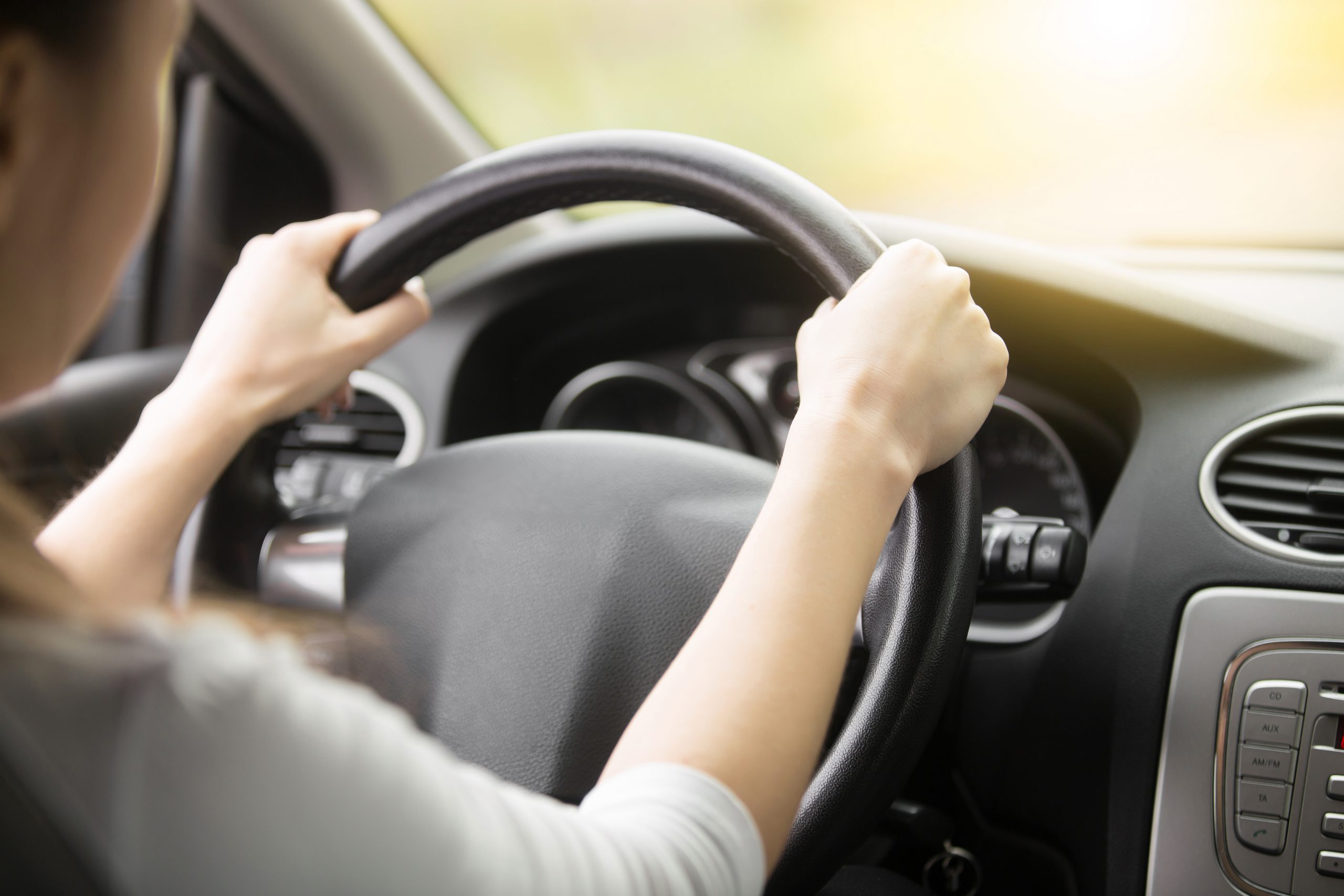 Close up of female with hands on the steering wheel